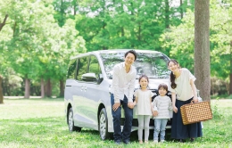 車の前で笑う家族の写真